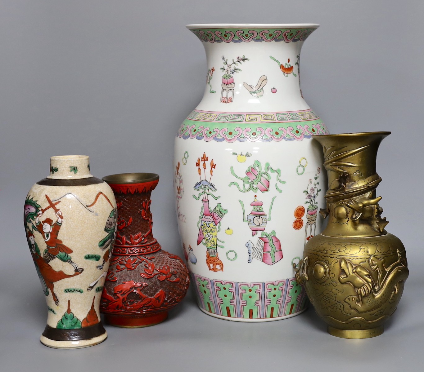 A Chinese crackle glaze ‘warriors’ vase, a famille rose ‘hundred antiques’ vase, a ‘cinnabar’ lacquer vase and a bronze ‘dragon’ vase, tallest 38cm